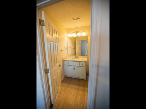 a bathroom with a sink and a mirror at Ohana Tides Home in Holden Beach