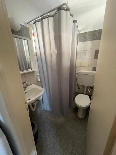 a bathroom with a toilet and a sink at Panorama Hotel in Kalymnos