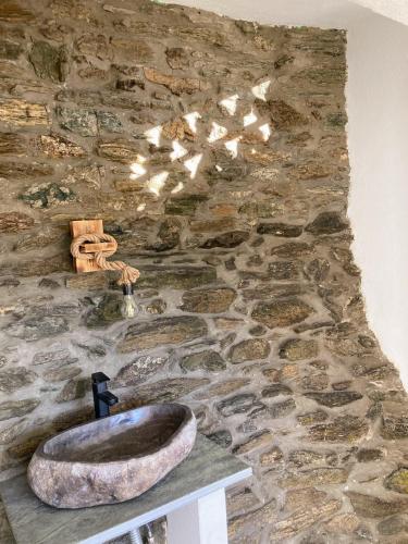 a stone bathroom with a sink and a stone wall at The Priest House in Makrotándalon