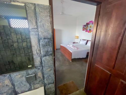 a view of a bedroom with a bed and a mirror at Whisky Point Surf Cabanas in Ampara