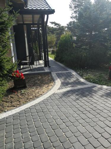 a brick walkway leading to a gazebo at Domki Pod Szyszką 500m od morza in Rowy