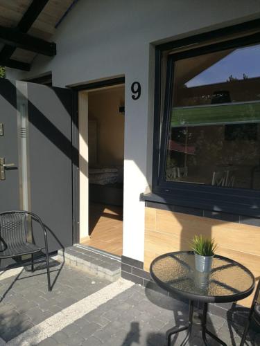 a patio with a table and chairs and a window at Domki Pod Szyszką 500m od morza in Rowy