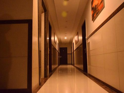 an empty hallway in a building with a hallway at Hotel Sai Jashan Shirdi - Where blessings & comfort meet in Shirdi