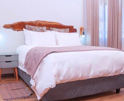 ein Schlafzimmer mit einem großen Bett mit weißen Laken und Kissen in der Unterkunft Narvira in Kona