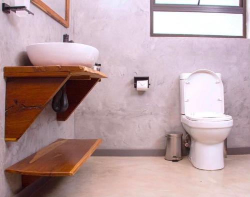 ein Badezimmer mit Waschbecken und Toilette in der Unterkunft Narvira in Kona