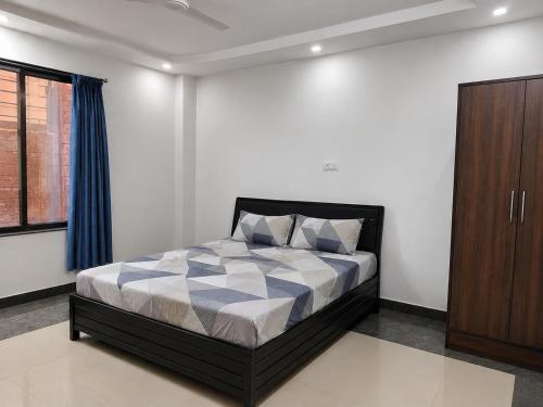 a bedroom with a bed and a wooden cabinet at Gods Gift in Murbād
