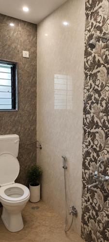 a bathroom with a toilet and a shower stall at Gods Gift in Murbād