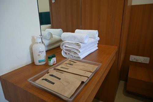 a table with towels and a tray with a bottle of soap at Shubhratna Hotel & Resort in Ujjain
