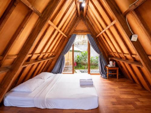 a bedroom with a bed in a room with wooden ceilings at New Dgyp Ciater Resort in Ciater