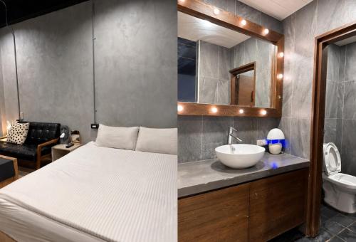 a bedroom with a bed and a sink and a mirror at 境域Loft自助民宿 in Kaohsiung