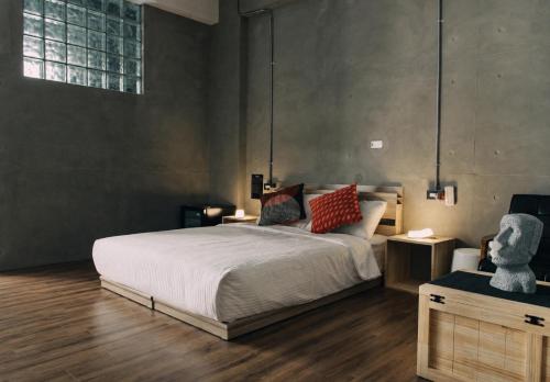 a bedroom with a large bed and a chair at 境域Loft自助民宿 in Kaohsiung