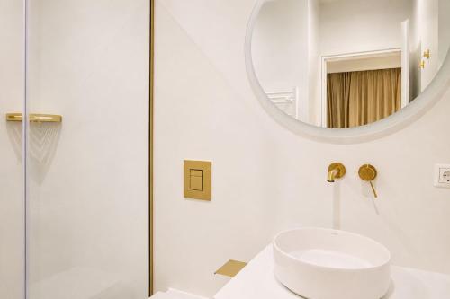 a white bathroom with a sink and a mirror at Gialova Sunset Apartment in Gialova