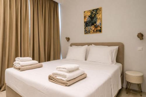 a bedroom with a bed with towels on it at Gialova Sunset Apartment in Gialova