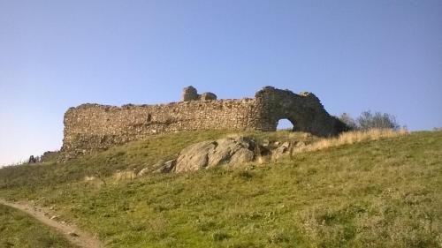 a castle on top of a hill with a dirt road at Pensiunea Aurelia in Şiria