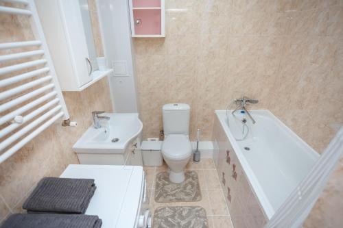 a bathroom with a toilet and a tub and a sink at Ion Creangă Residence in Chişinău