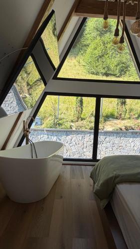 a bathroom with a tub in front of a window at Mia A-Frame Chalet Cheia in Cheia
