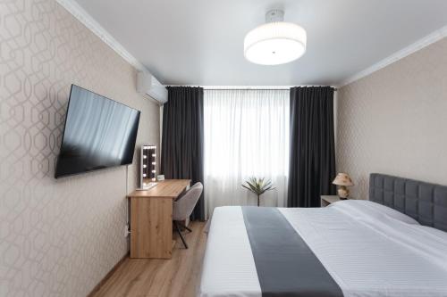 a hotel room with a bed and a desk and a television at Ion Creangă Residence in Chişinău