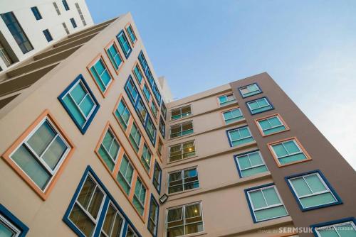 a tall building with colorful windows on it at Right Place Sathorn in Bangkok