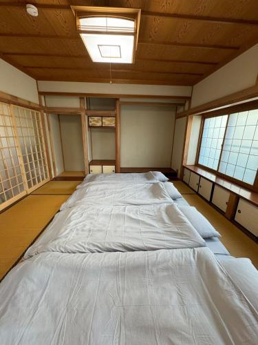 a large bed in a room with two windows at Laina 31 in Sumoto