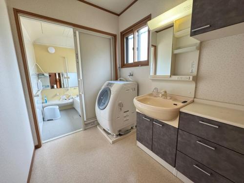 a bathroom with a sink and a washing machine at Laina 31 in Sumoto