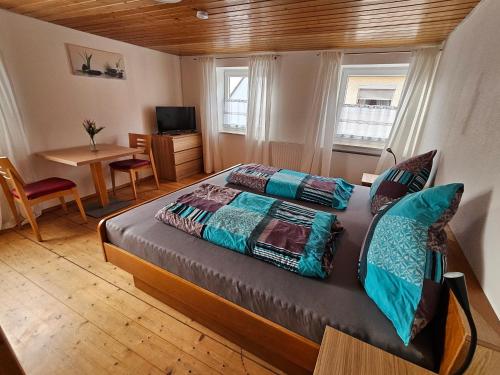 a bedroom with a bed and a table and a desk at Hofruhe in Neresheim