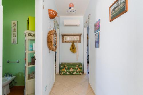 a hallway with a bathroom with green walls at Casina dei Capperi by Vivimy in Torre Pali