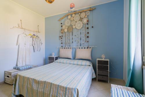 a bedroom with a bed with a blue wall at Casina dei Capperi by Vivimy in Torre Pali