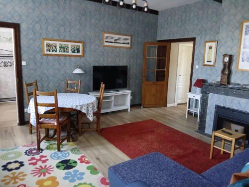 a living room with a table and a fireplace at Maison Marcadieu in Maubourguet