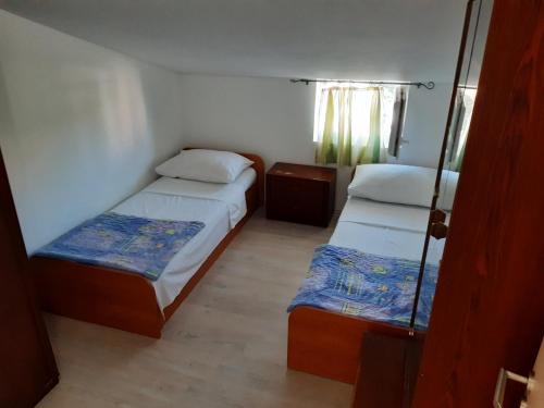 a small room with two beds and a window at Apartman Jednosoban, Dvosoban, Trosoban in Sukošan