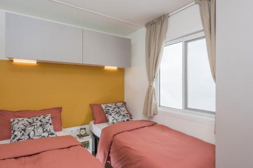 a bedroom with two beds and a window at Camping Village Il Sole in Marina di Grosseto