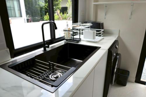 a kitchen sink with a dish drying rack above it at Chiang Rai Home with Full Kitchen in Ban Pa Sang (1)