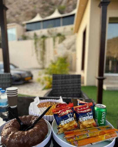 a table with two plates of food and snacks at Wadi Bani Khalid Guest house in Dawwah