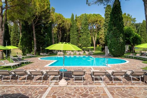 a swimming pool with chairs and an umbrella at West Garda Hotel in Padenghe sul Garda