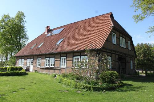 a large brick building with a red roof at Ferienwohnung Hof Alms in Uelzen