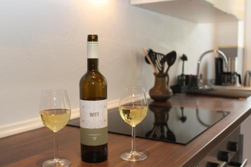 a bottle of wine and two glasses on a counter at Ferienwohnung Hof Alms in Uelzen