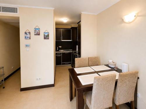 a kitchen and dining room with a table and chairs at Красавиците тъмнокоси Sunset Family in Pomorie