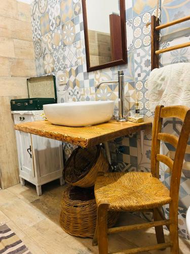 a bathroom with a counter with a sink and a chair at A casa di Meggie in Dogliola