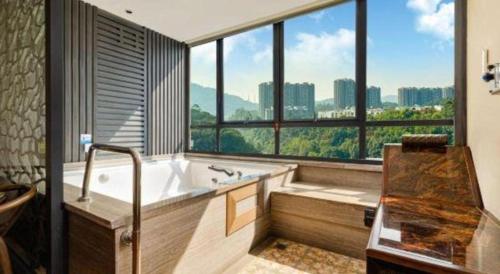 a large bathroom with a tub and a large window at HELSTON HOTEL in Guancun