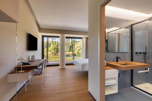 a bathroom with a sink and a desk and a mirror at Best Western Plus Carolus Park Hotel in Sutri