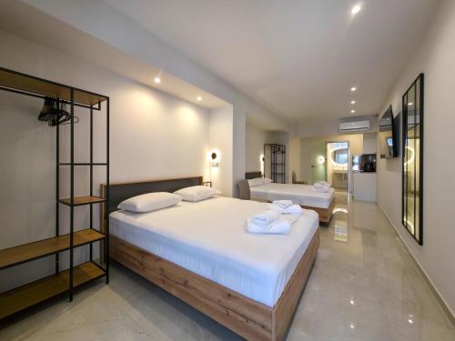 a bedroom with two beds with towels on them at Lucia Hotel Paralia in Paralia Katerinis