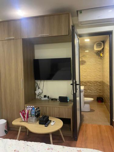 a living room with a tv and a table in a room at Flick Zone Trung Lực in Lực Hánh