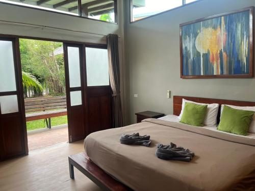 a bedroom with a bed with two pairs of shoes on it at Slow Life Sabaidee Pai in Pai