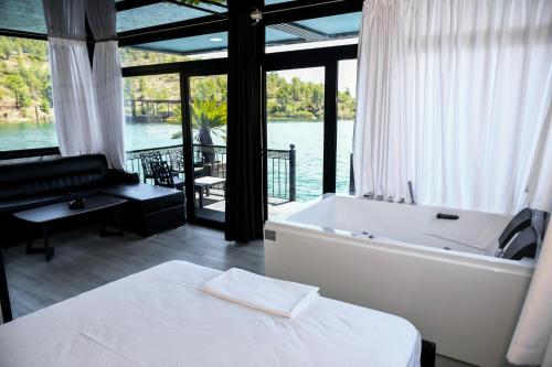 a bedroom with a tub and a bed with a view of the water at Dream house in Rragam