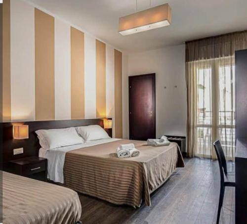 a hotel room with two beds with towels on the bed at Nuovo Hotel Diamante in Cesenatico
