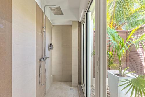 a bathroom with a shower and a plant at Villa Karma by muse villas in Grand-Baie