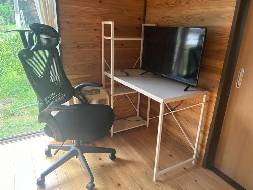 a room with a desk and a chair and a television at Kibe House in Kunisaki