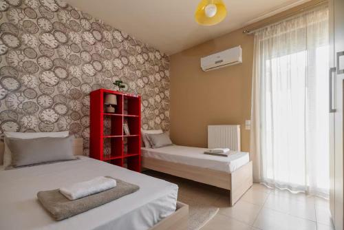 a bedroom with two beds and a red shelf at Beach Bar VIlla in Lefkada