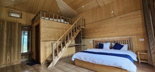 a bedroom with a bed and a wooden wall at The Himalayan Monarch in Chakrāta