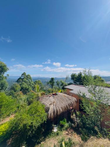 a small hut with a thatched roof on a hill at Sana's homestay haputhale in Haputale