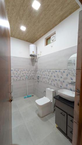 a bathroom with a toilet and a sink at The Himalayan Monarch in Chakrāta